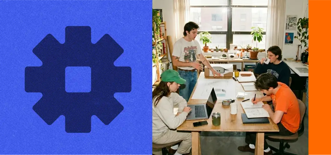 A product team collaborating around a table with laptops in a bright, plant-filled studio